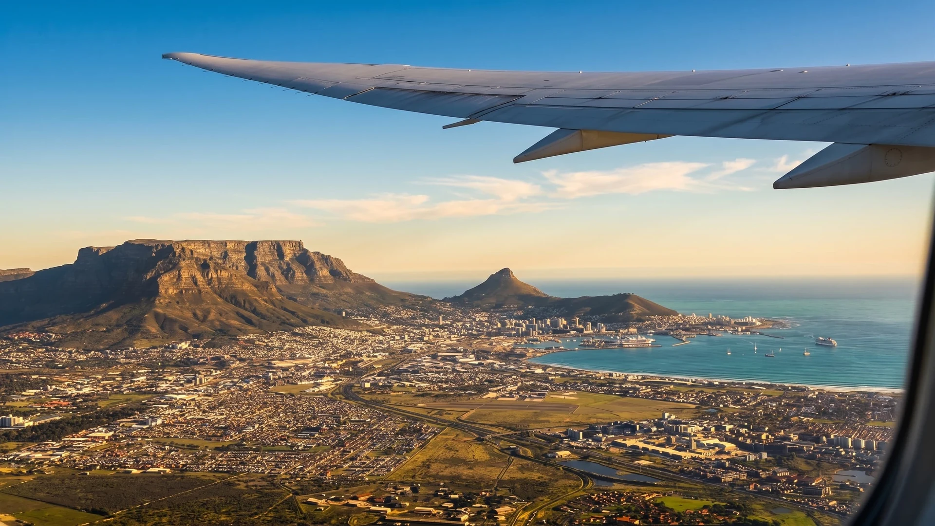 Aerial view of Cape Town and Table Mountain from a plane window, wing in frame