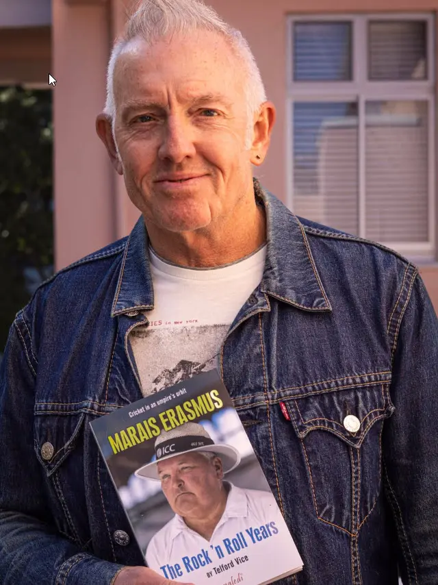Telford Vice in a denim jacket, holding a book