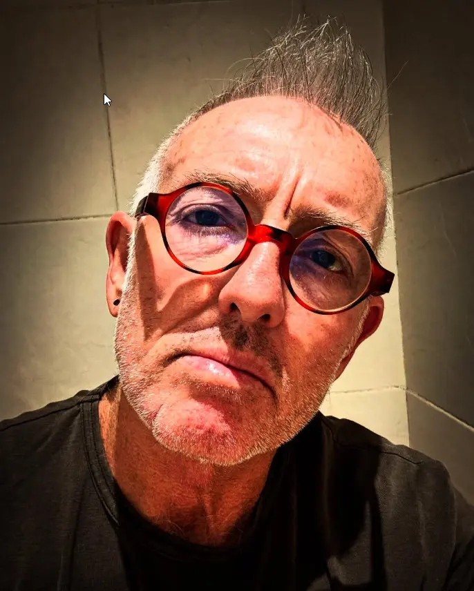 Telford Vice in round red glasses, low-light portrait